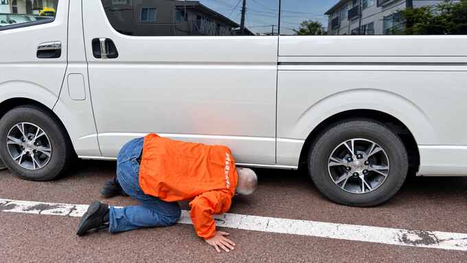 車体の下をのぞき込んで確認する小野店長